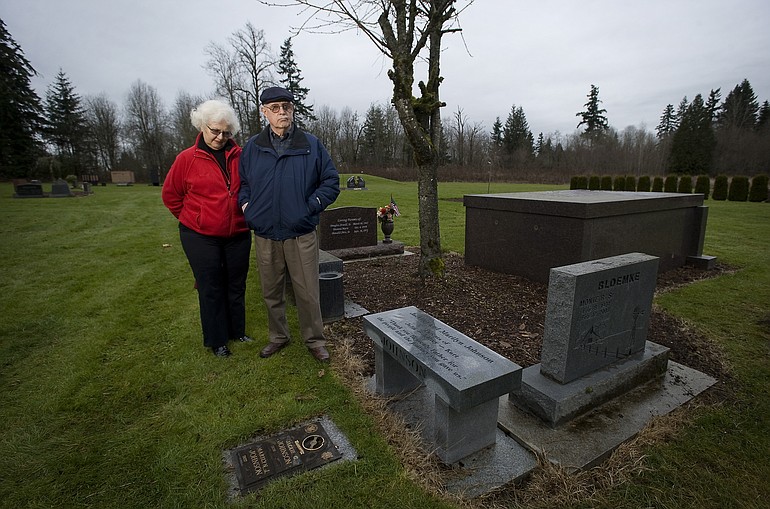 Vancouver residents Jack and Marilyn Johnson stand  next to the grave site, grave marker and bench they purchased in advance at Northwood Park Cemetery in Ridgefield.