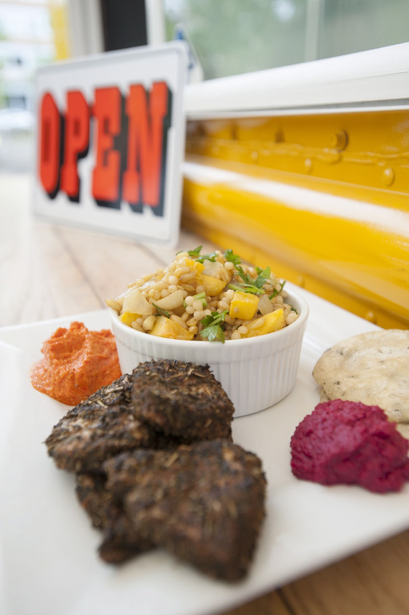A plate of roasted beet hummus, grilled chicken with kamut (in the bowl) with roasted red pepper and almond sauce is served April 23 at Ingrid's Goodstreetfood truck in Vancouver.