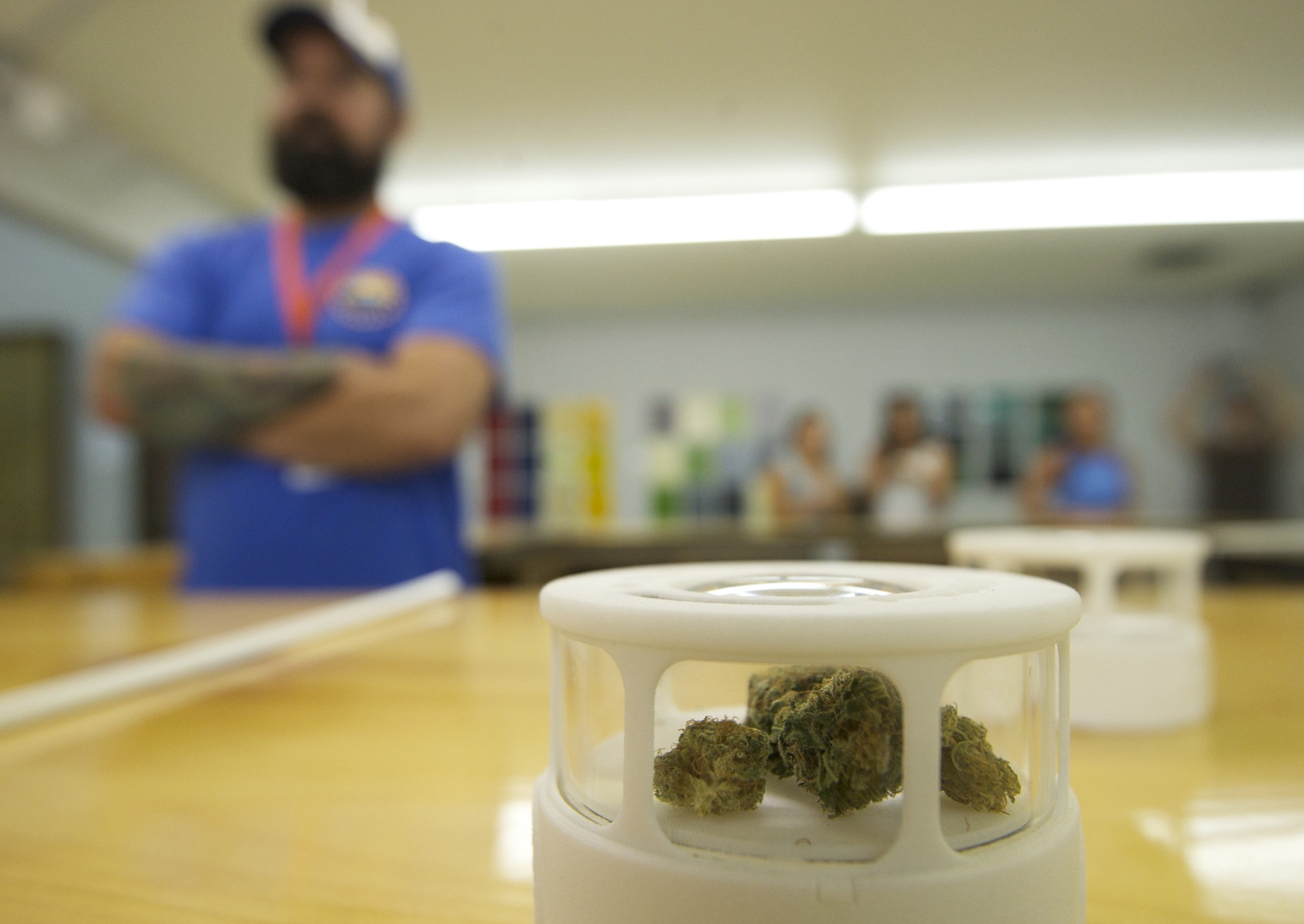 Customers have the opportunity to inspect different strains of marijuana for sale during the grand opening of New Vansterdam marijuana shop on July 11.