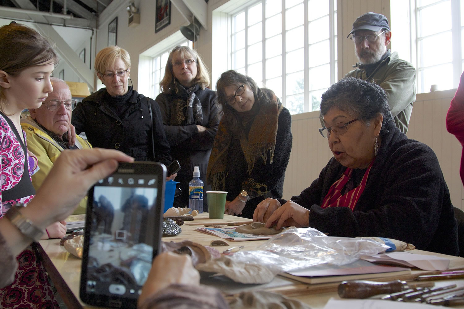 A crowd watches renowned artist Lillian Pitt demonstrate how to make a traditional Native American mask out of clay during a workshop at Pearson Air Museum in Vancouver on Saturday.