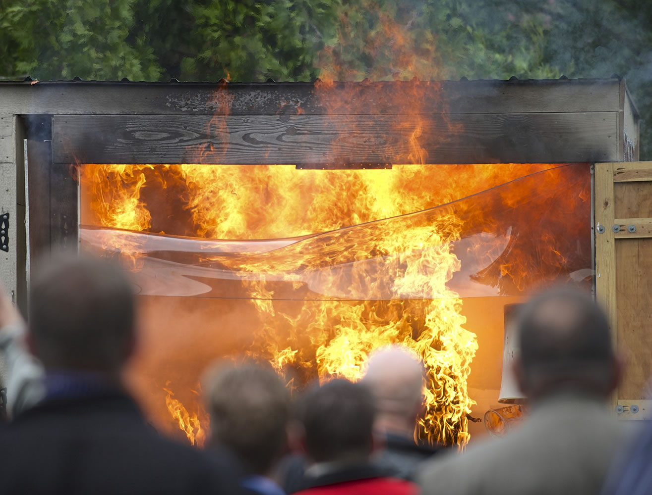 Spectators watch a live-burn demonstration Thursday that was organized by fire officials to show how fire sprinklers work.