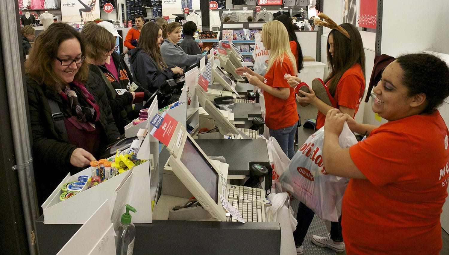 Dawn Leonard, front left, of the Brush Prairie area checks out of Old Navy at the Westfield Vancouver Mall as Mika Smith, right, helps out.