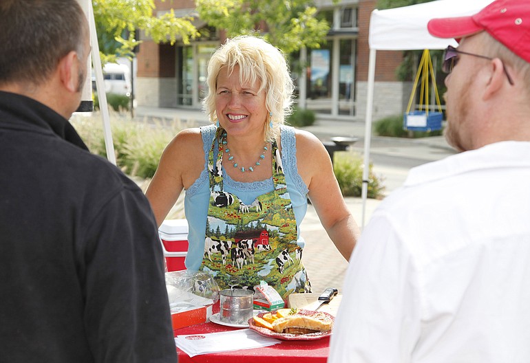 Liz Pike chats with shoppers and offers french toast samples from her cooking demonstration using organic eggs from her own chickens at the Washougal Farmers Market Saturday.