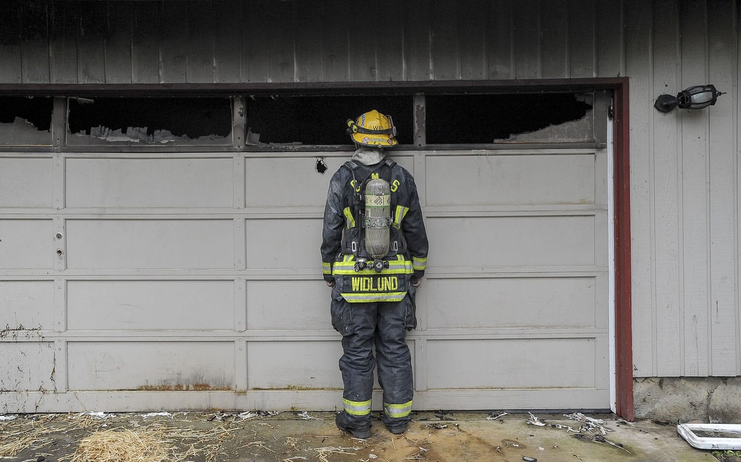 Firefighter Mark Widlund looks into a garage during a training burn at a house in Camas.