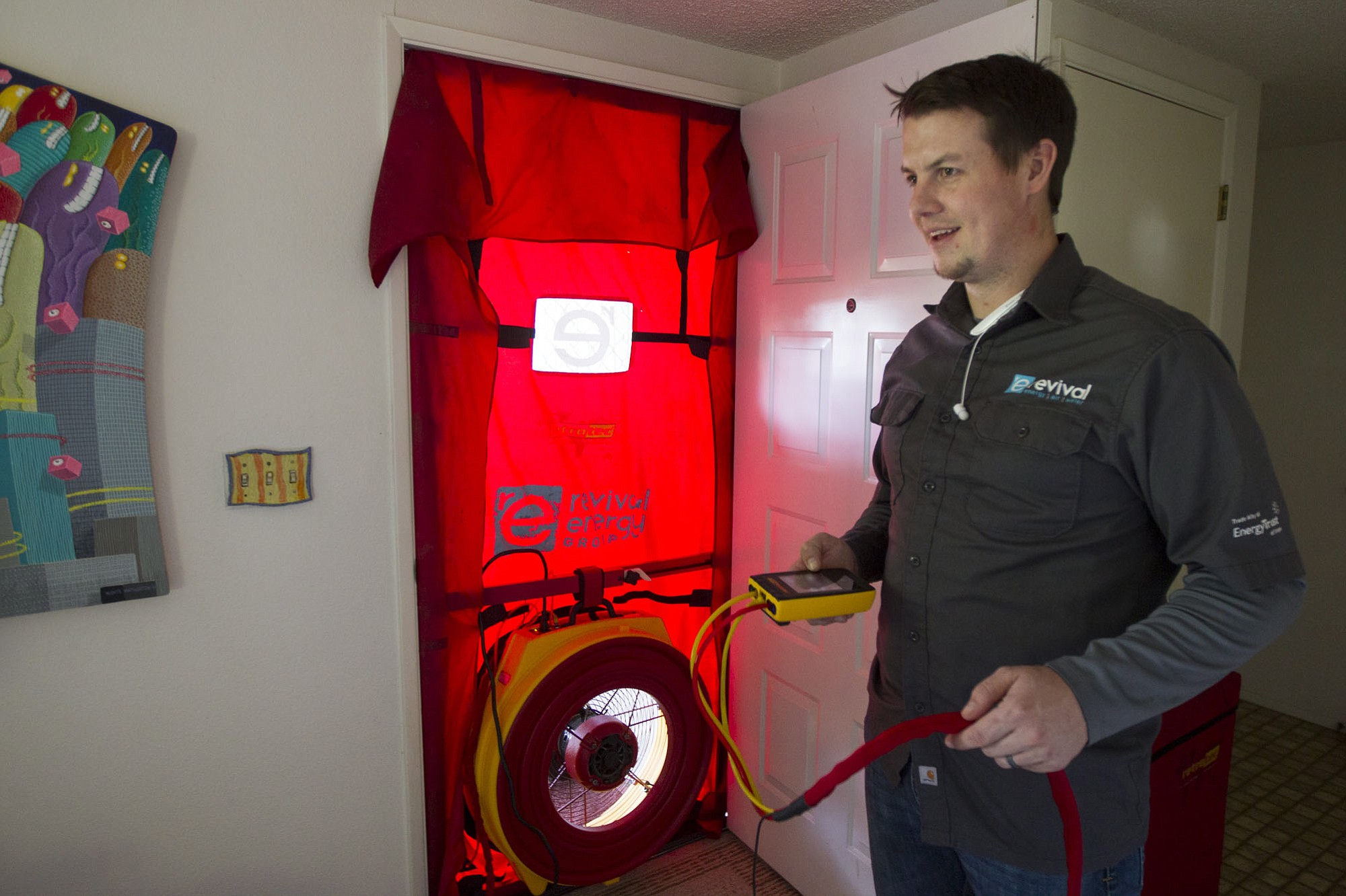 Revivial Energy Group's Robert Brierley conducts a pressure test to detect heat or cool air leaks as part of an energy audit in the Cascade Park home of Kaye and Monte Wolverton.