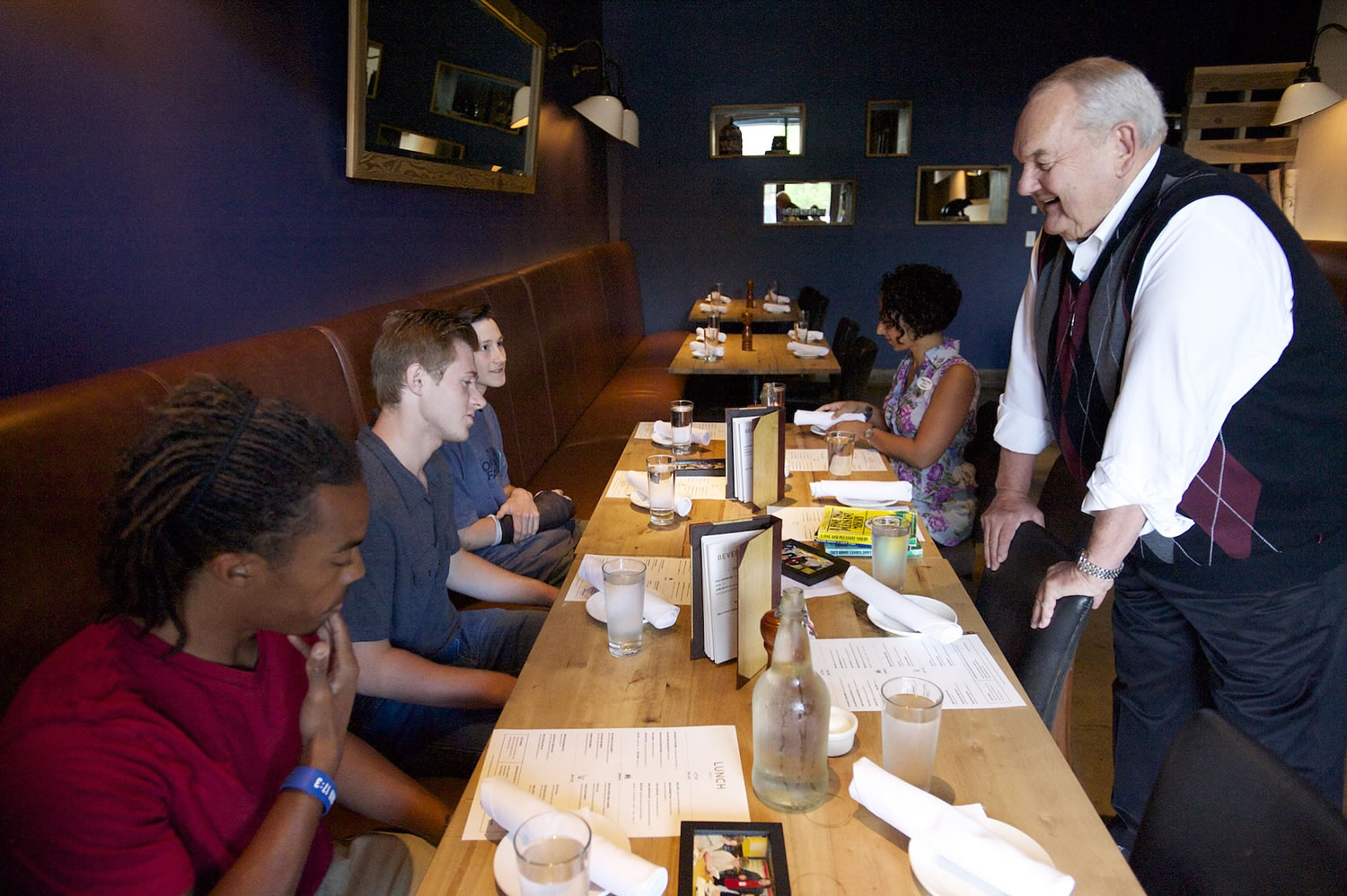 Longtime Lunch Buddy Steve Runyan greets Isaiah Ephraim, from left, Nathan Harris and Seth Hunt at Lapellah for a grown-up lunch Friday. Nine years ago Runyan began meeting with his three lunch buddies, who all attended low-income Martin Luther King Elementary.