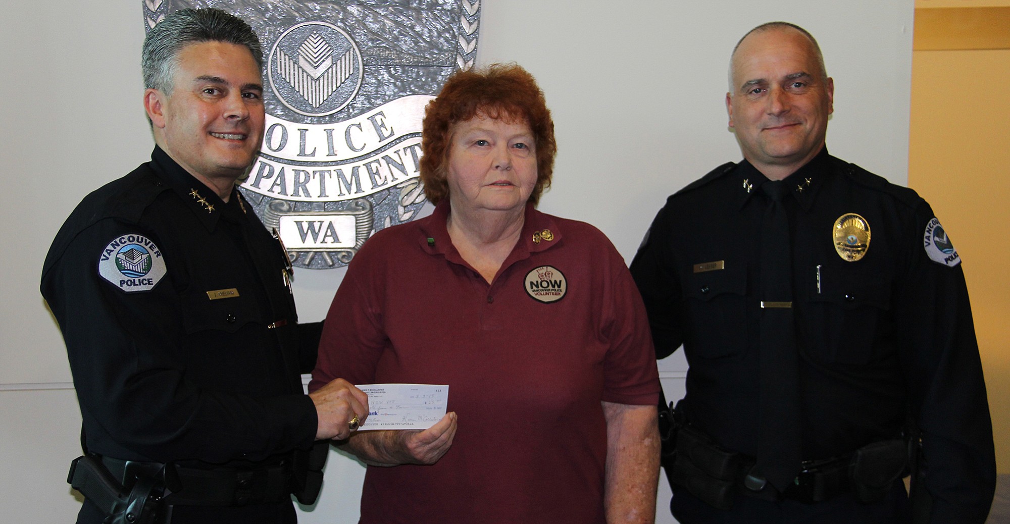 Bagley Downs: Vancouver Police Chief James McElvain, left, and Assistant Chief Mike Lester, right, accepting a $1,400 check from Karen McCallister and various neighborhood associations for the Neighbors on Watch program, which they donated in honor of her late husband, Edward &quot;Lee&quot; McCallister.