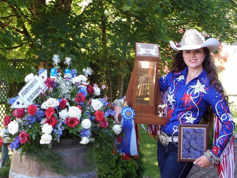 Felicia Harrison holds the trophy and plaque after winning the Rodeo or Fair Queen Award at this year's Rose Festival Grand Floral Parade.