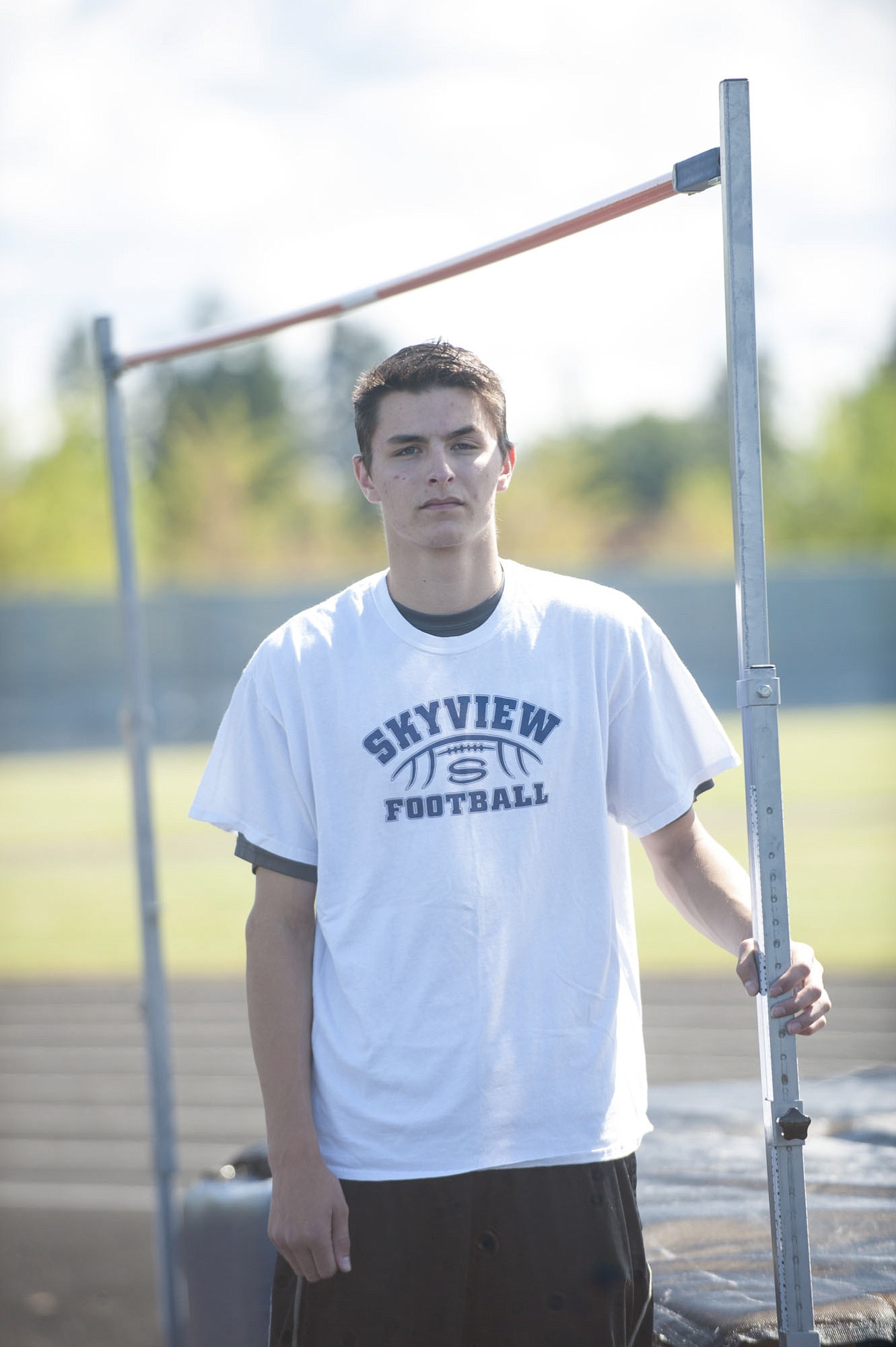 Skyview's Peyton Fredrickson, who stands 6-foot-3, poses under the high jump bar that is set at 6-10, the school-record height he cleared earlier this season.