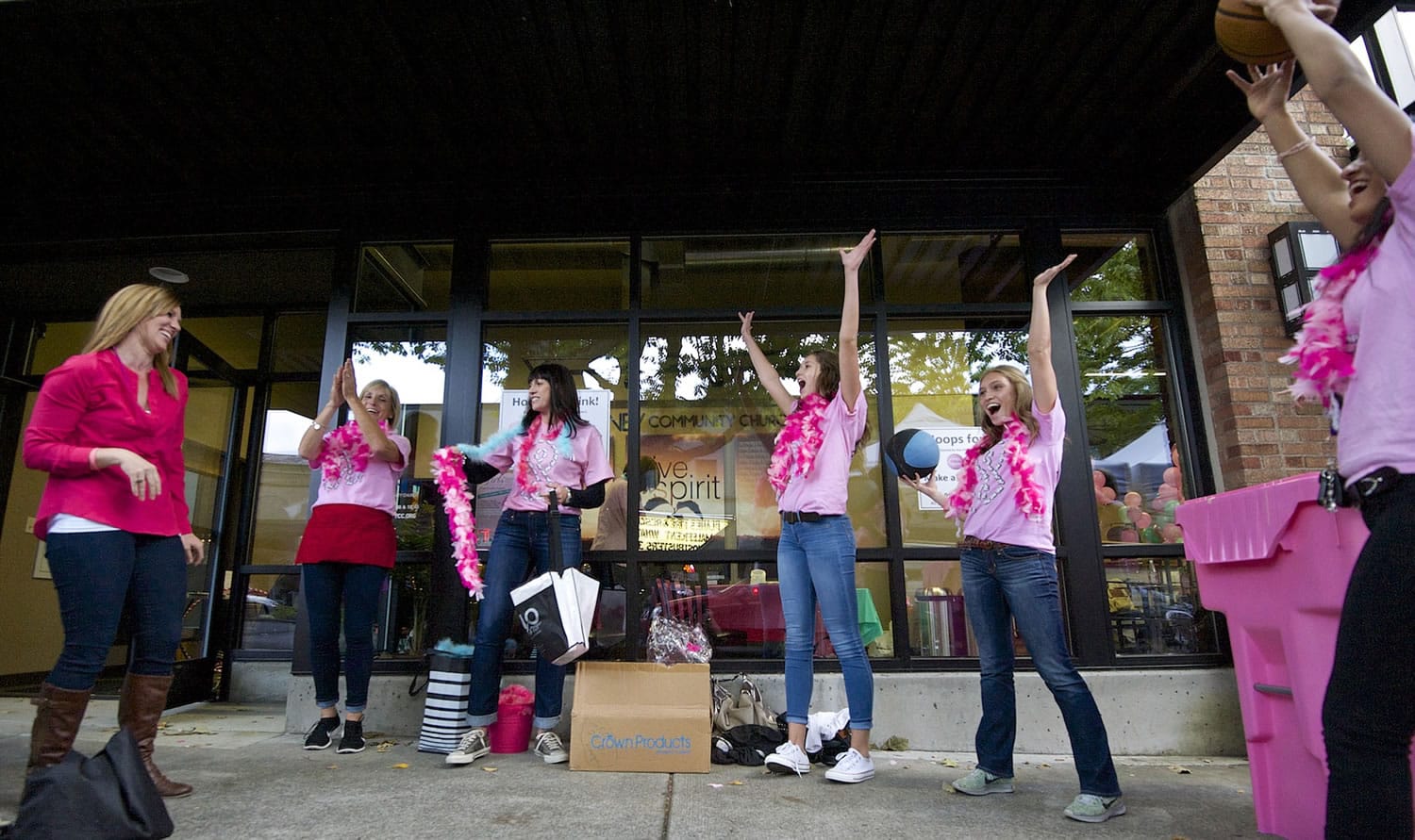 Shayna Hamilton, left, is cheered by members of the Camas High School girls basketball team after making a shot in to a pink recycling bin during the Downtown Camas Association's Girls' Night Out on Sept. 25.