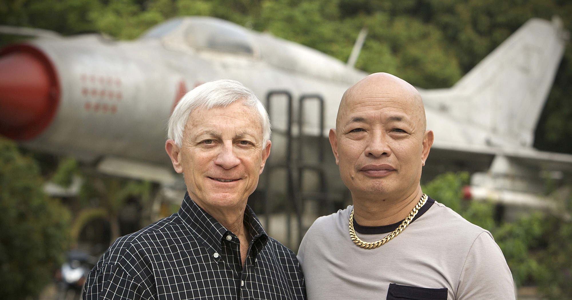 Opposing Vietnam War fighter pilots Dan Cherry, left, and Nguyen Hong My in front of a MiG-21 jet at the Vietnam Military History Museum in Hanoi.