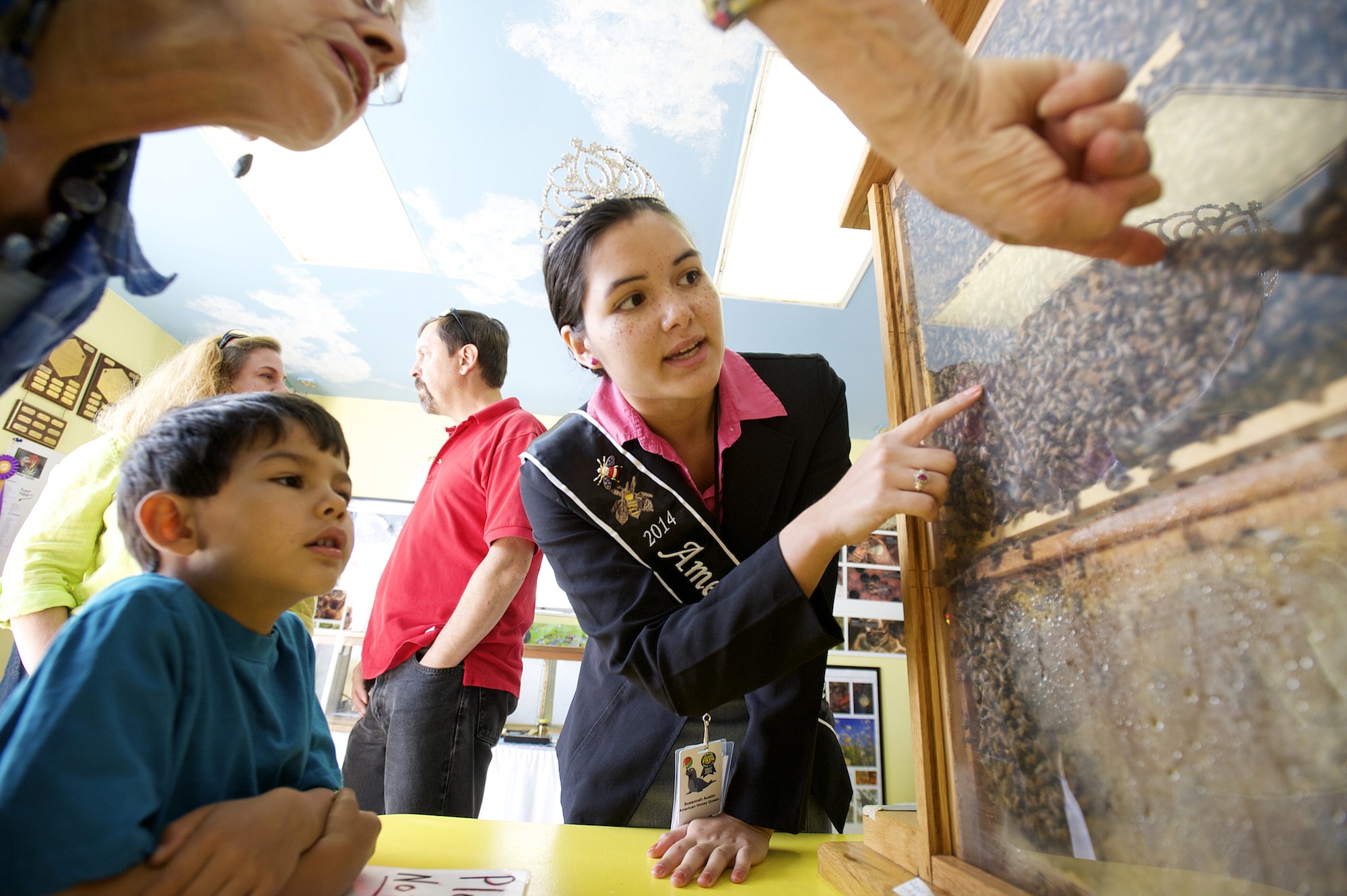 Photos by Steven Lane/The Columbian
American Honey Queen Susannah Austin talks about honey bees with Nivaran Sarki, 6, and his grandmother Kareen Messerschmidt, both from Vancouver, at the Clark County Fair Wednesday.