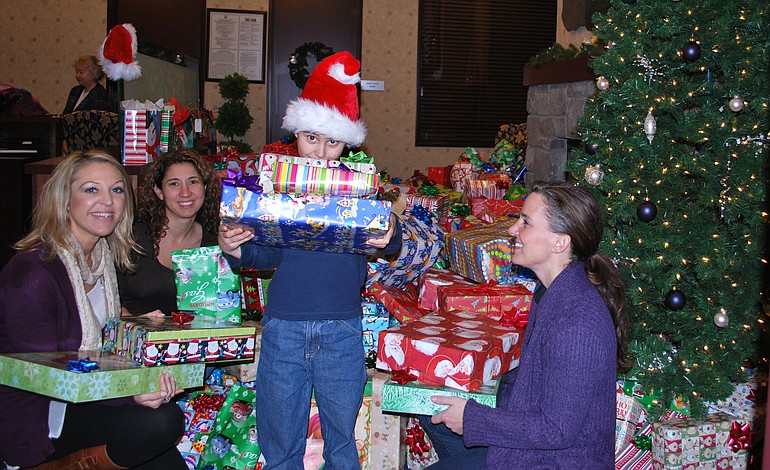 Esther Short: Riverview Bank employees and their families -- including , from left, Jessica Douglas, Jennifer Konopasek and son Austyn Konopasek, and Gina Williams -- donated nearly 400 gifts to foster children through the Shirley DuPaul Gifts for Kids in Care program.