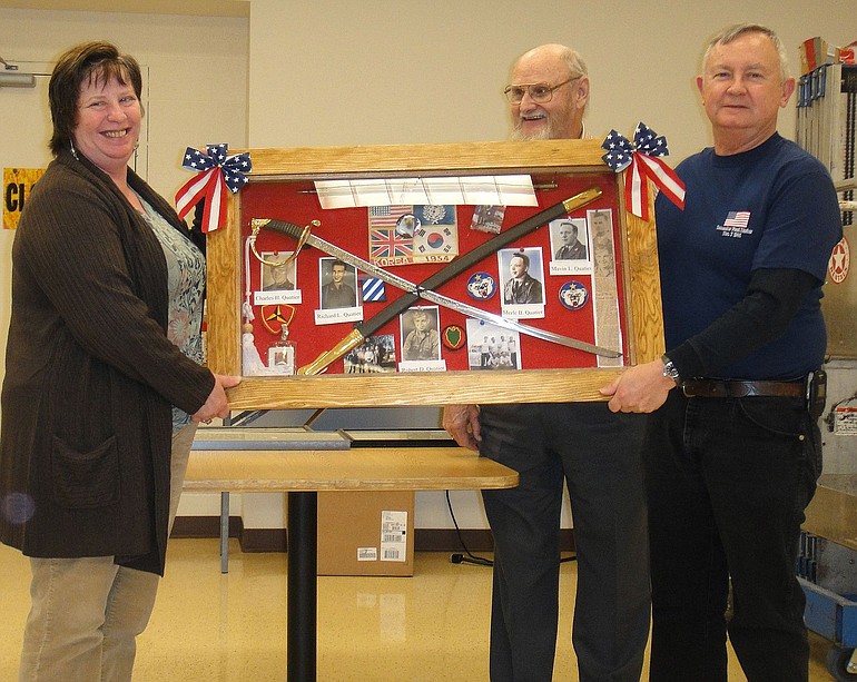 Northeast Hazel Dell: Debbie Quatier presents a military display donated from the Quatier family to the Rev. Jerry Keesee, center, and Jack Giesen, treasurer of the Vancouver Barracks Military Association.