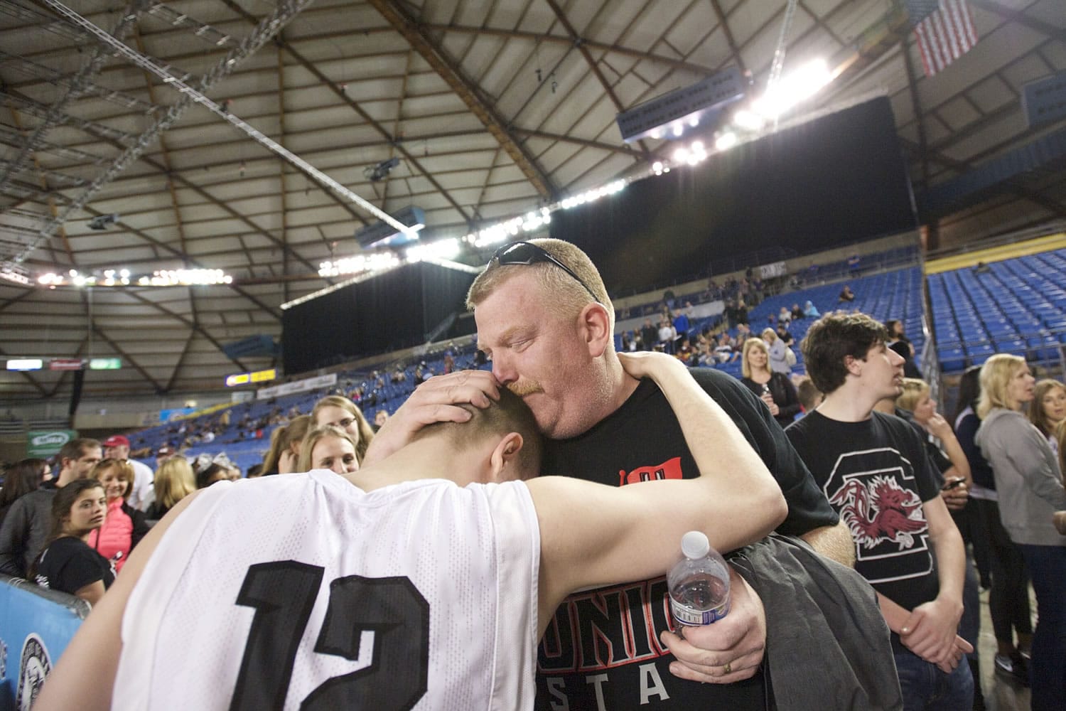 Doug Paulson comforts his son Micah Paulson as Union beats Woodinville 69-45 to win third place at the 2015 WIAA Hardwood Classic 4A Boys tournament at the Tacoma Dome, Saturday, March 7, 2015.