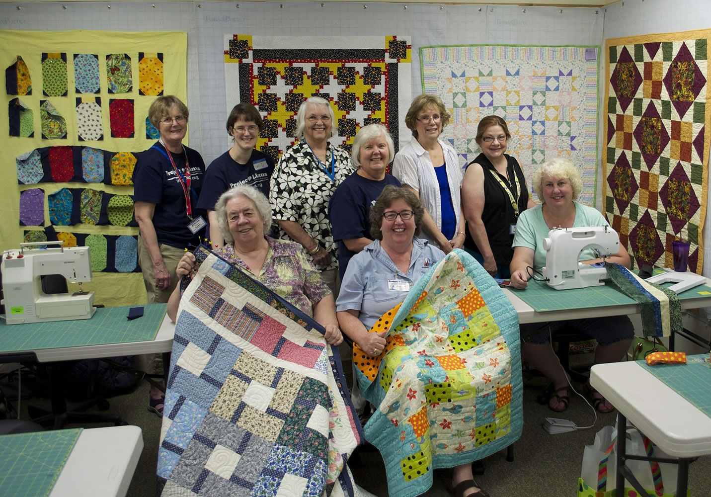 Northeast Hazel Dell: Project Linus members pose with quilts they made for children in need during a recent gathering at A Quilt Forever. Back row, from left: Lys Leitner, Lori Tate, Brenda Mitchell, Sandy Hubbard, Lynda Van de Grift, Nancy Foley-Hibberd, Cindy Strom.