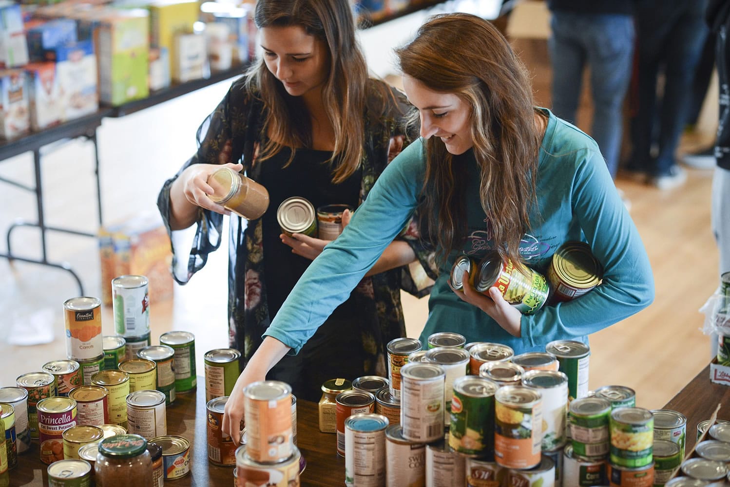 Crissaya Wood, left, and Meghan Ashton, seniors at Columbia Adventist Academy, sort donated food for The Children's Center during a volunteer outing Wednesday morning.