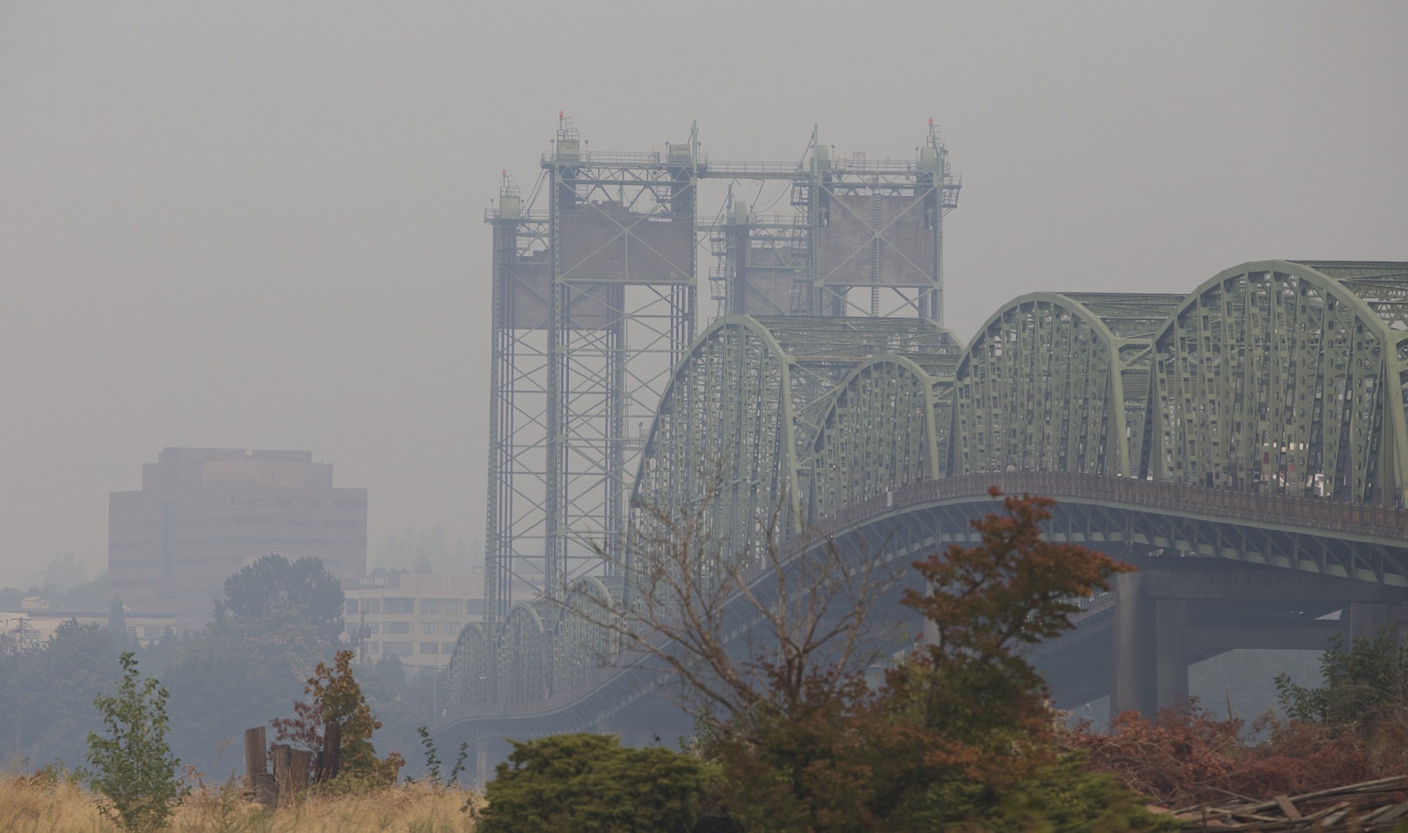 A pall of smoke blankets the Interstate 5 Bridge and downtown Vancouver on Saturday afternoon after a wind shift brought smoke and ash from Washington wildfires into the area.