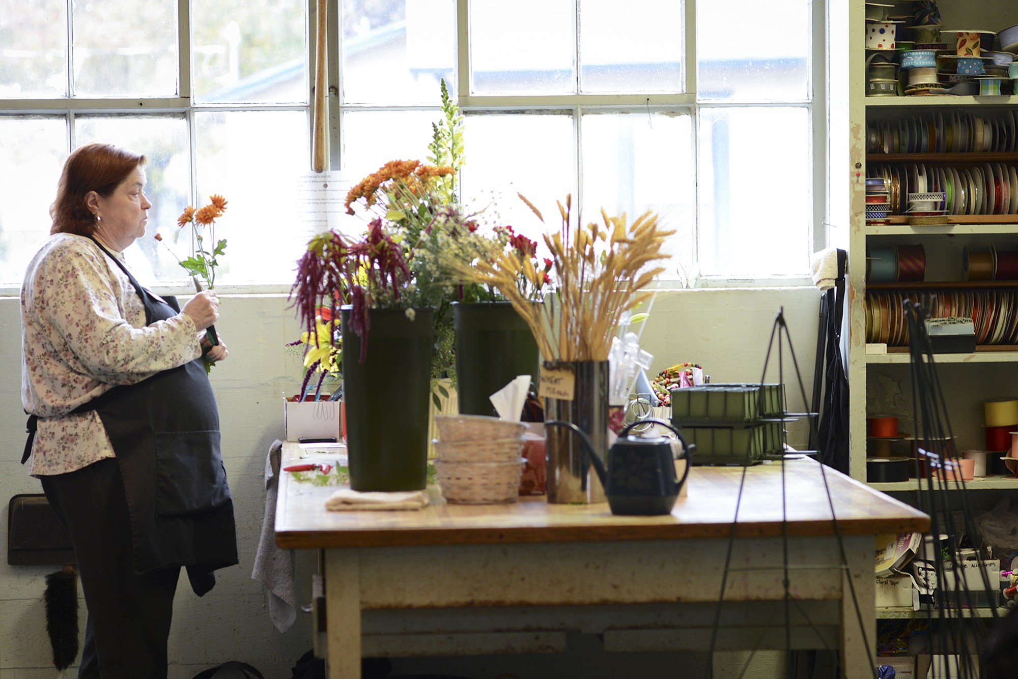 Longtime employee Gretchen Van De Water assembles a floral arrangement for a funeral Thursday at Luepke Florist.