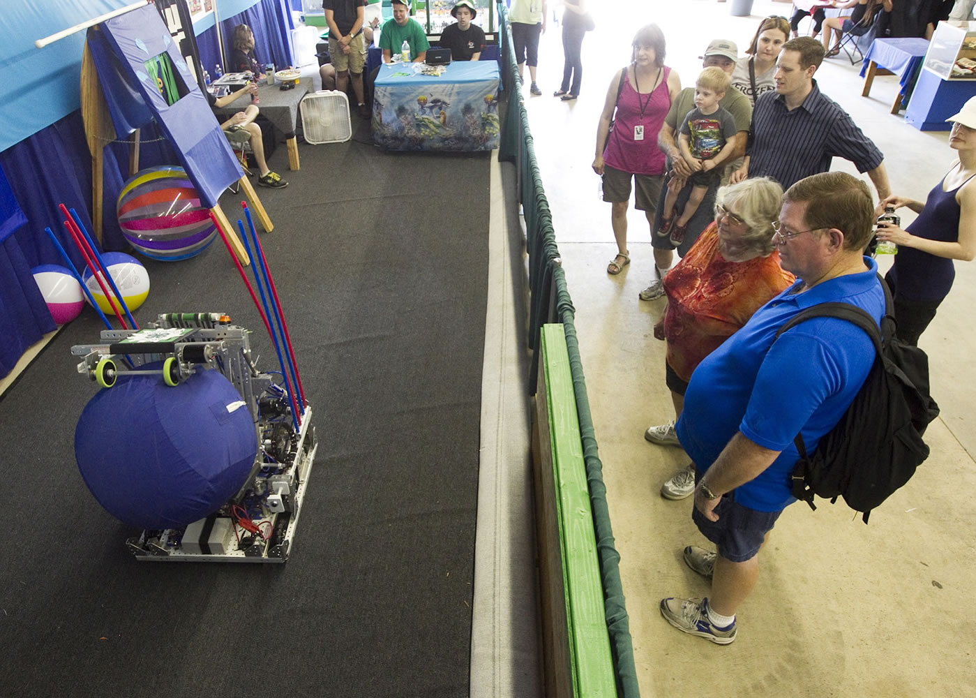 Visitors stop to watch a demonstration of a robot throwing a ball at the Clark County Fair. The 4-H high school robotics team made the robot for the annual robotics competition.