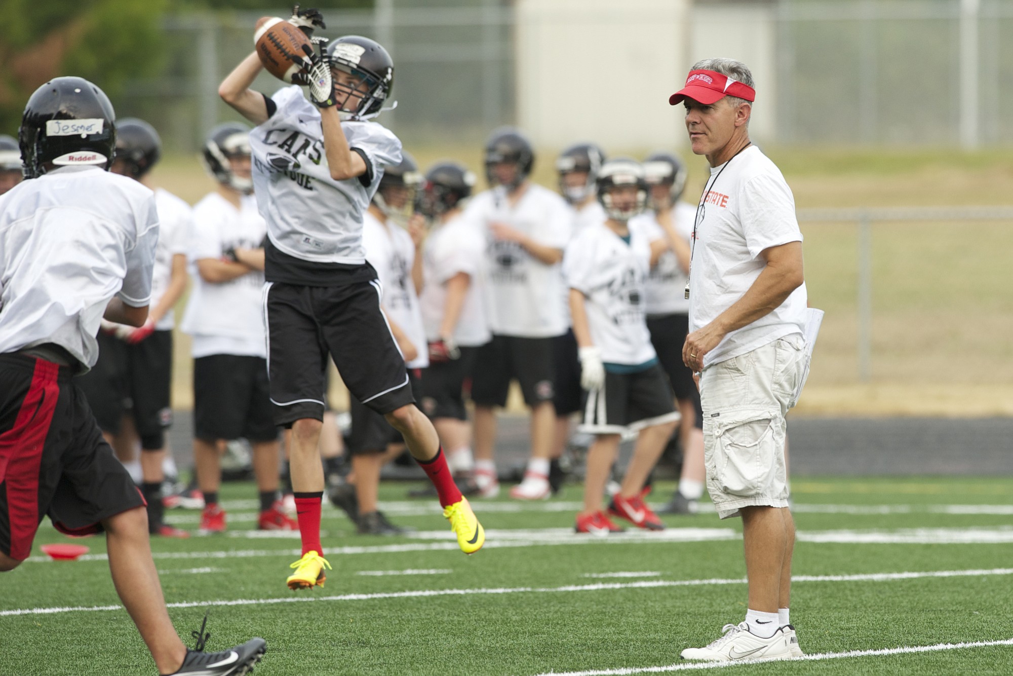 Camas football head coach Jon Eagle works with his team during an August 22, 2013, practice.