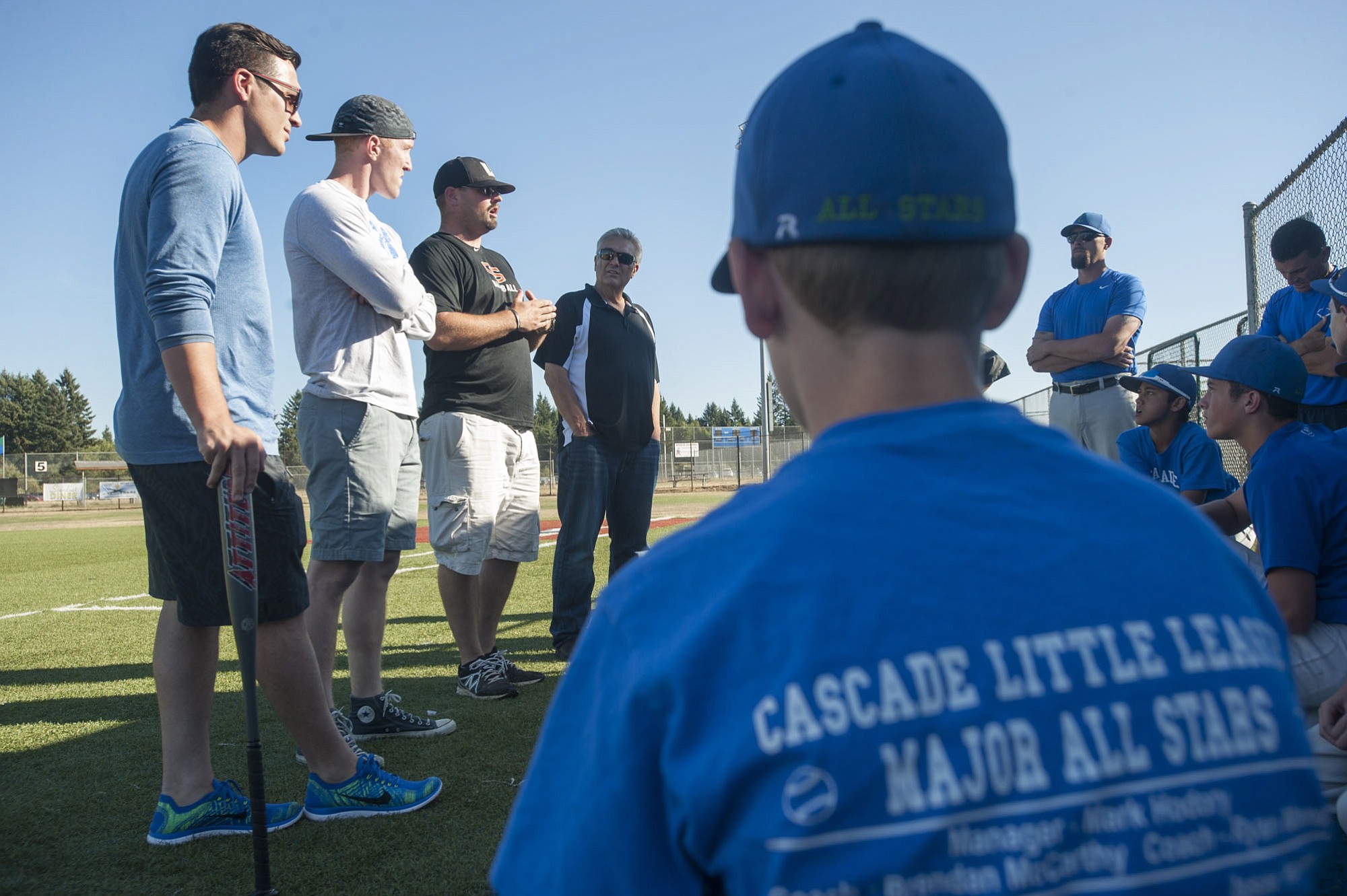 From left, former Hazel Dell Little League baseball players Jay Ponciano, Jackson Evans, Union High School coach Ben McGrew and former Hazel Dell coach Jim Ponciano give the Cascade Little League players advice prior to practice in Vancouver on Tuesday August 4, 2015.