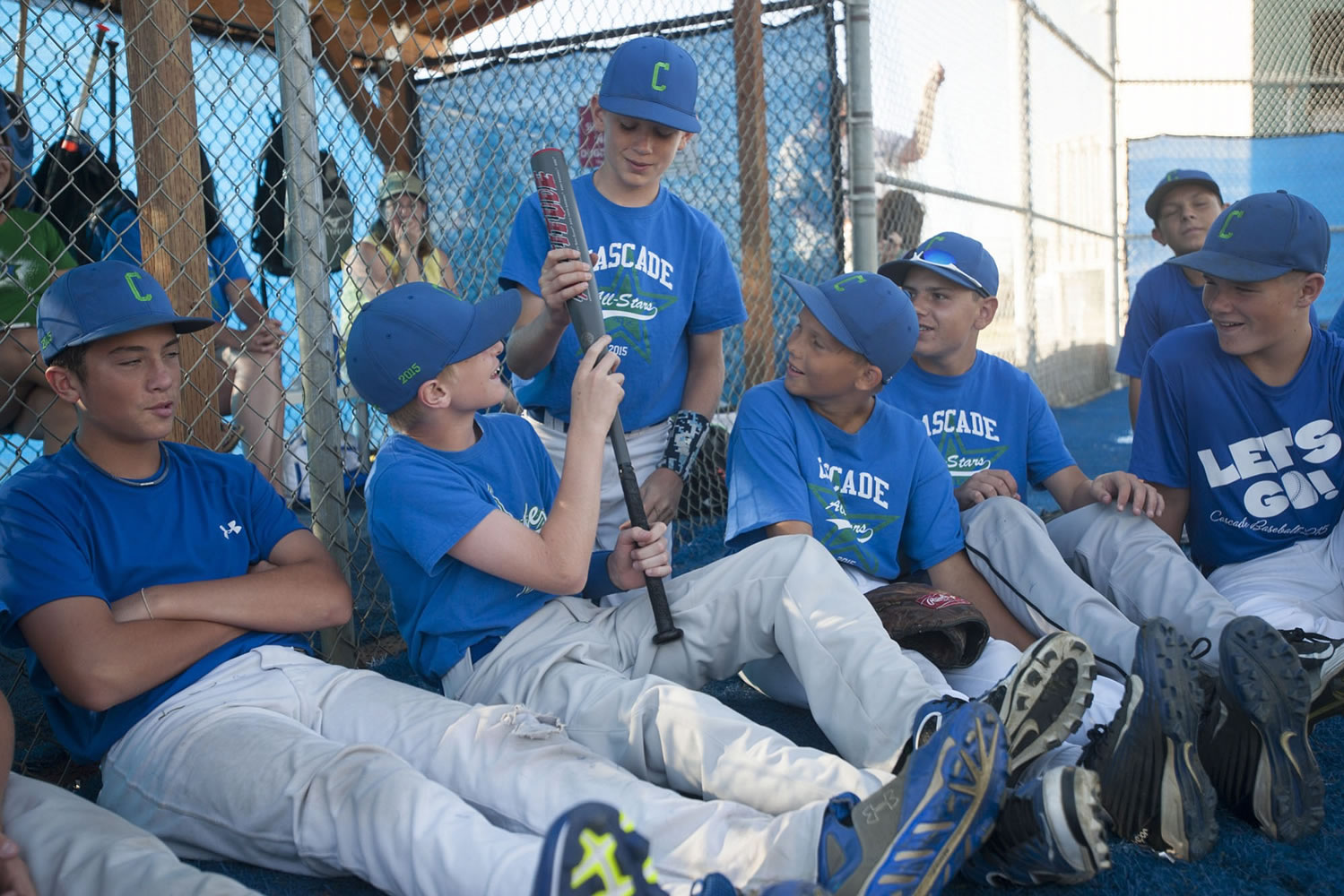 Ben Jones (2nd from left) and his teammates from the Cascade Little League look at a bat from the 2000 Little League World Series given to them by Jay Ponciano, who played on that Hazel Dell team.