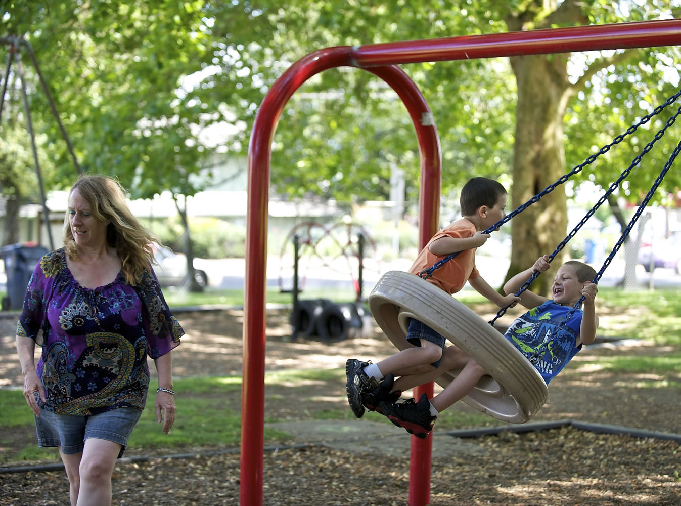 Lori Sanders, of Vancouver, gets out of the way after giving her grandchildren Landon, 5, left, and Elysia 7, a push on the tire swing at Crown Park in Camas on Tuesday July 8, 2014. Family Circle magazine named Camas as one of the 10 best cities in America for families.