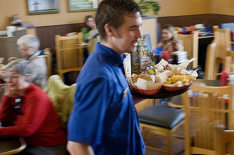 An employee serves diners at the Salmon Creek Burgerville.