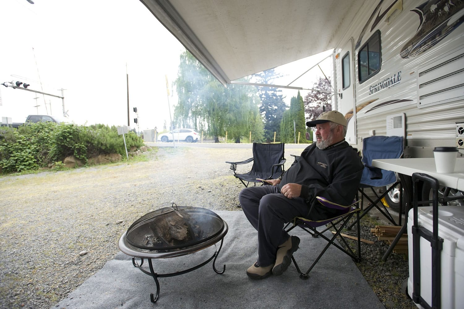 Washougal Mayor Sean Guard waits Thursday for the next train to pass during his weeklong vigil near the railroad crossing at 32nd Street in Washougal.