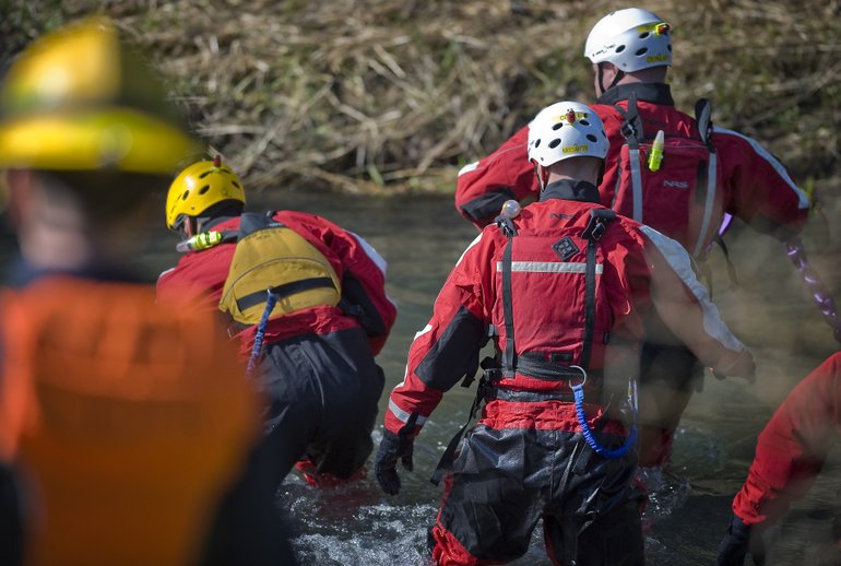Firefighters from the regional technical rescue team recover a body in the Little Washougal River on Monday.