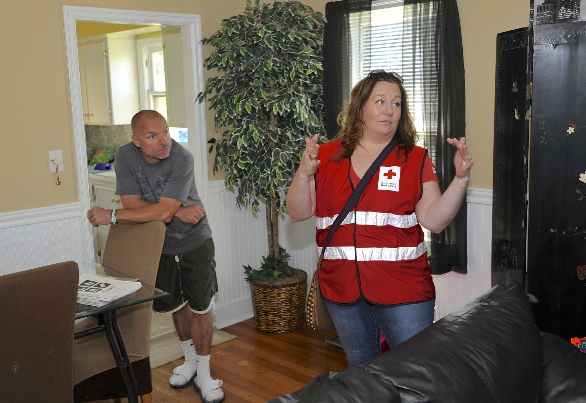 Red Cross volunteer Jessica Chapman, right, talks with residents including Kevin Brown as a group install smoke alarms in Vancouver.