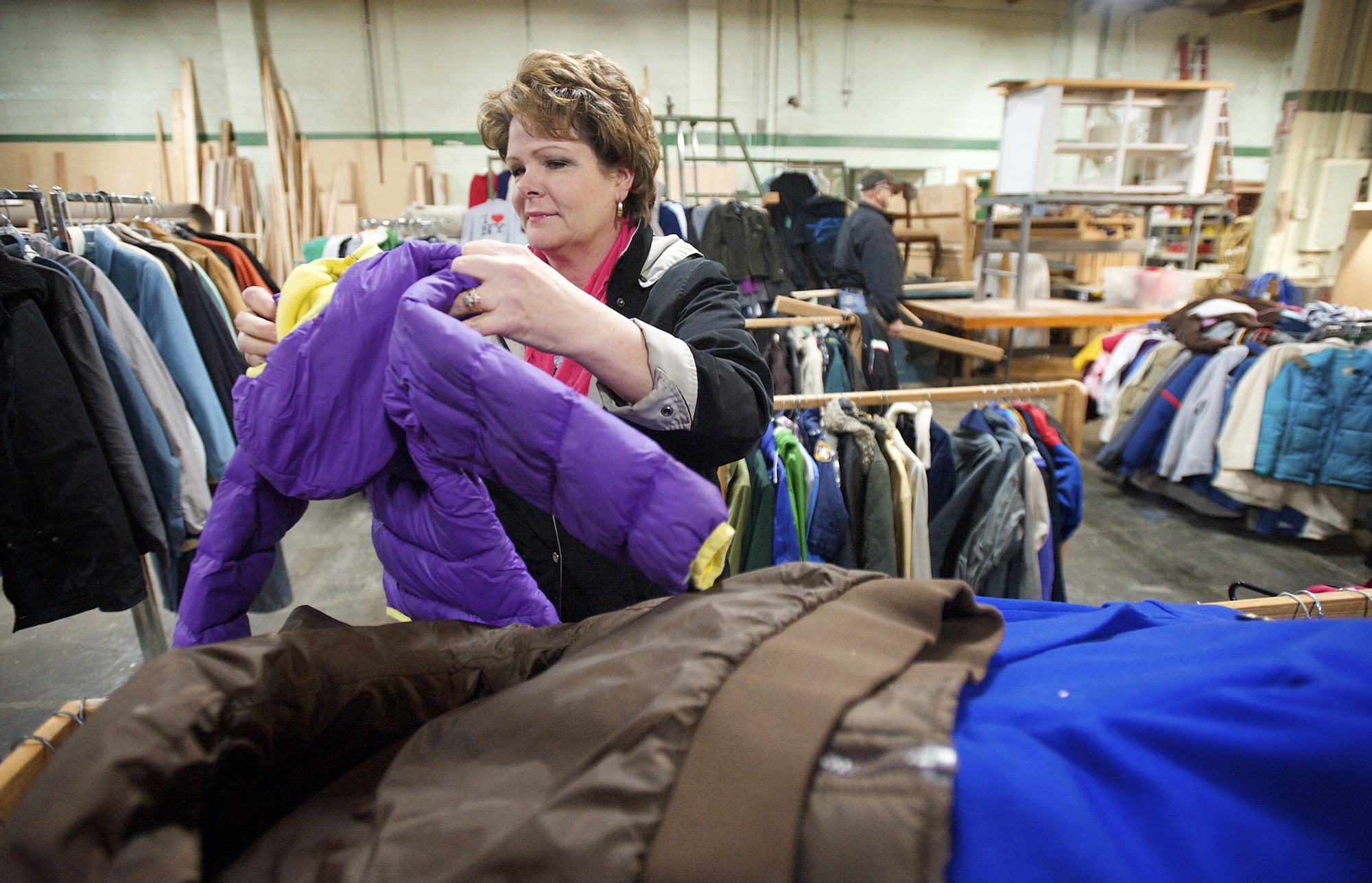Robin Anderson, from the Rotary Club of Greater Clark County, selects children's coats Friday at the Friends of the Carpenter center.