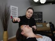 Tara Lee does &quot;threading&quot; on Brittany McKedy, which is an ancient, noninvasive hair-removal method.