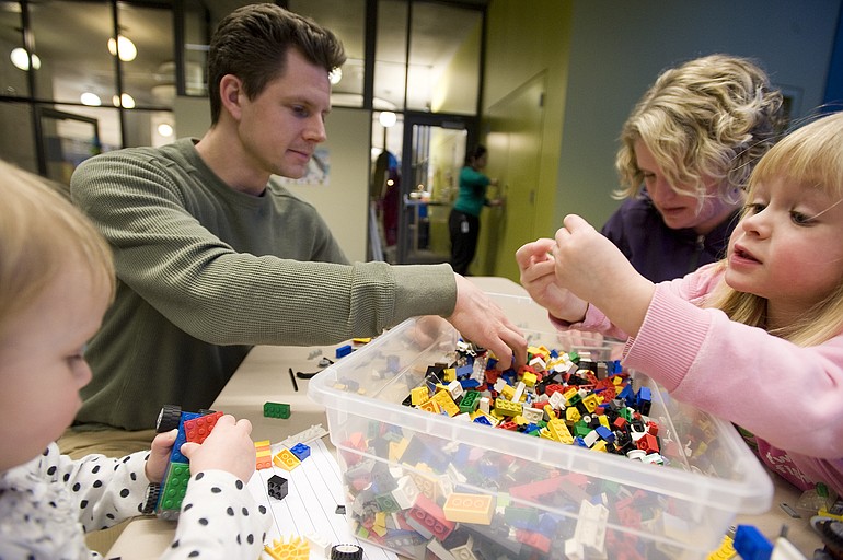 The Collmer family, from left, Vivian, 2, Chris, Sarah, and Lucy, 4, play with LEGOs at the new Vancouver Community Library on Tuesday.
