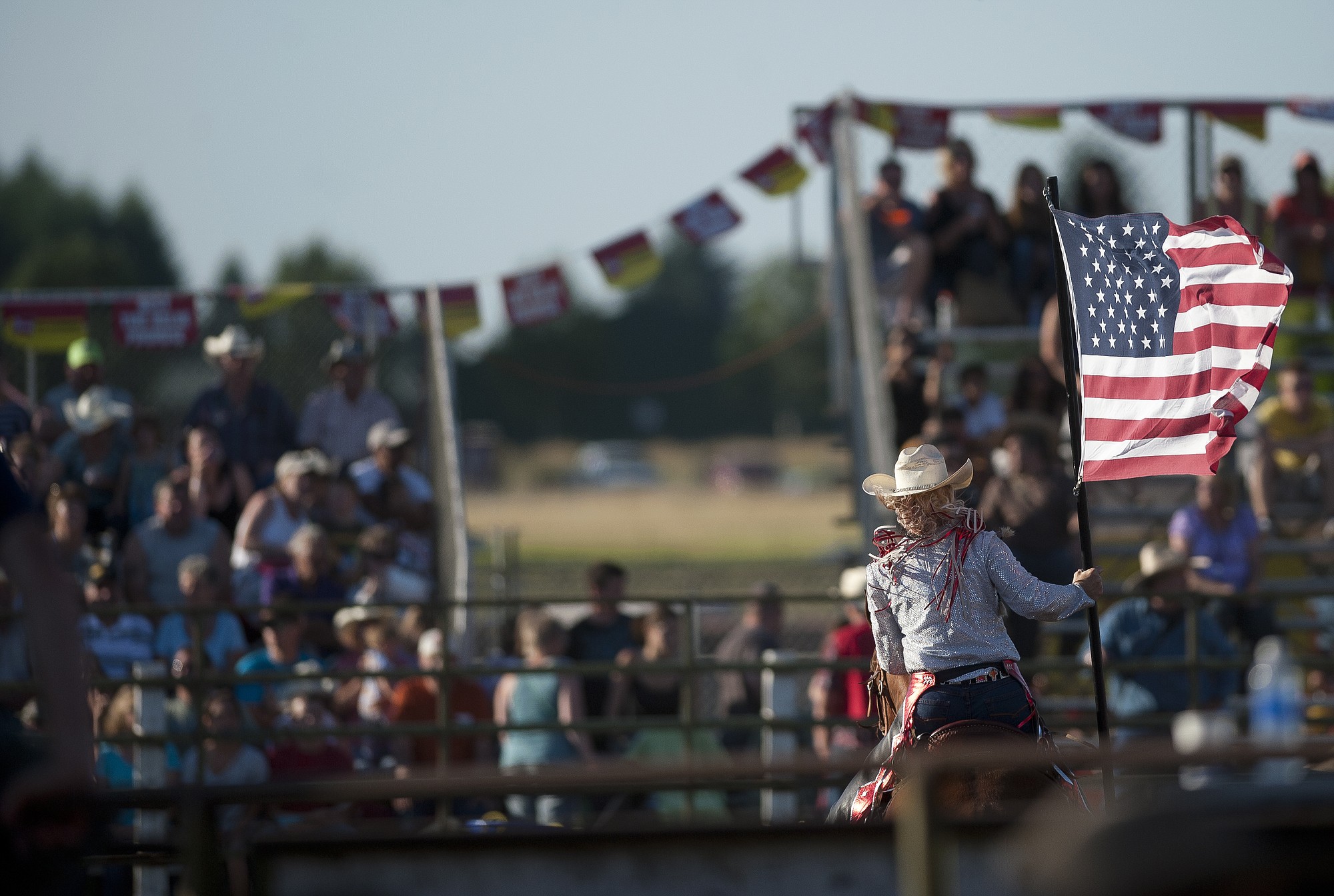 A rider carries an American flag at the beginning of the Vancouver Rodeo at the Clark County Saddle Club on Saturday July 7, 2012.