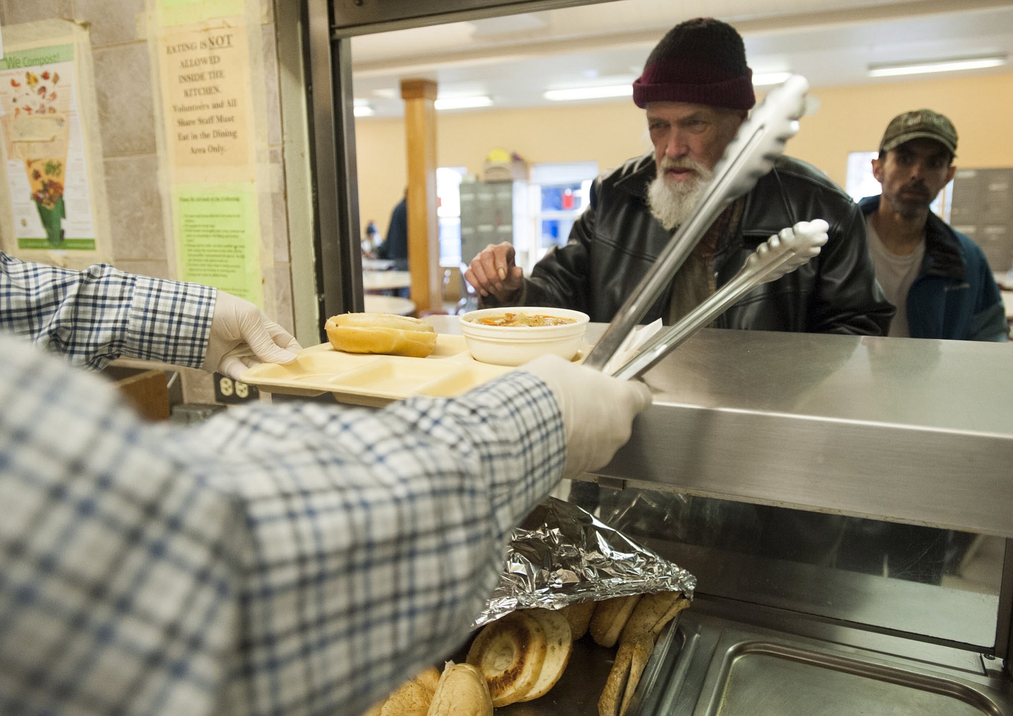 Volunteers serve lunch to the homeless at Share House in Vancouver on Thursday.