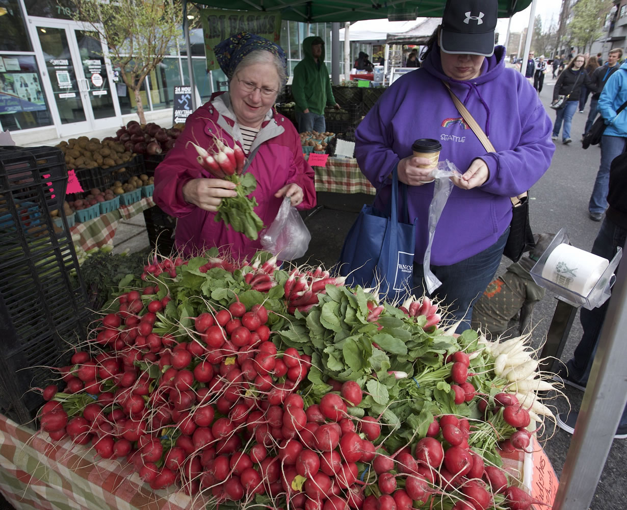 Photos by Steve Dipaola for the Columbian
Shoppers select fresh vegetables Saturday -- the second day of spring -- at the first Vancouver Farmers Market of 2015.
