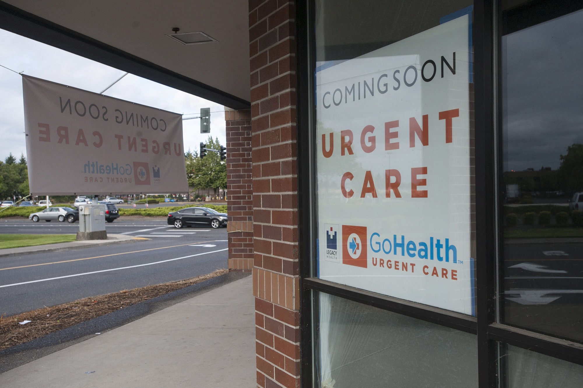Signs announce the impending arrival of the Legacy-GoHealth Urgent Care at Mill Plain Boulevard and Chkalov Drive in Vancouver. The new clinic is scheduled to open Aug.