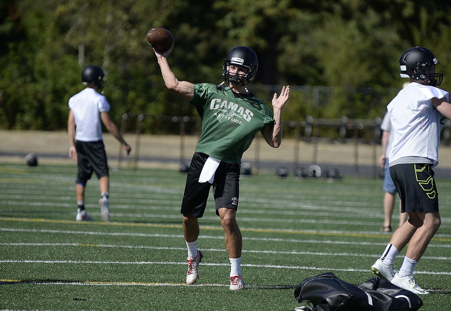 Camas High School's Liam Fitzgerald, center, throws to a teammate during practice Wednesday afternoon, August 19, 2015, at the school's practice field.