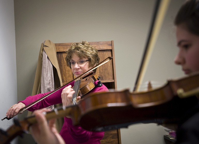 Kathy Barry, 62, here with student Mikayla Blackwell, 16, teaches violin and viola at Beacock Music Co. 30 hours a week. Barry lost her Basic Health coverage in December.