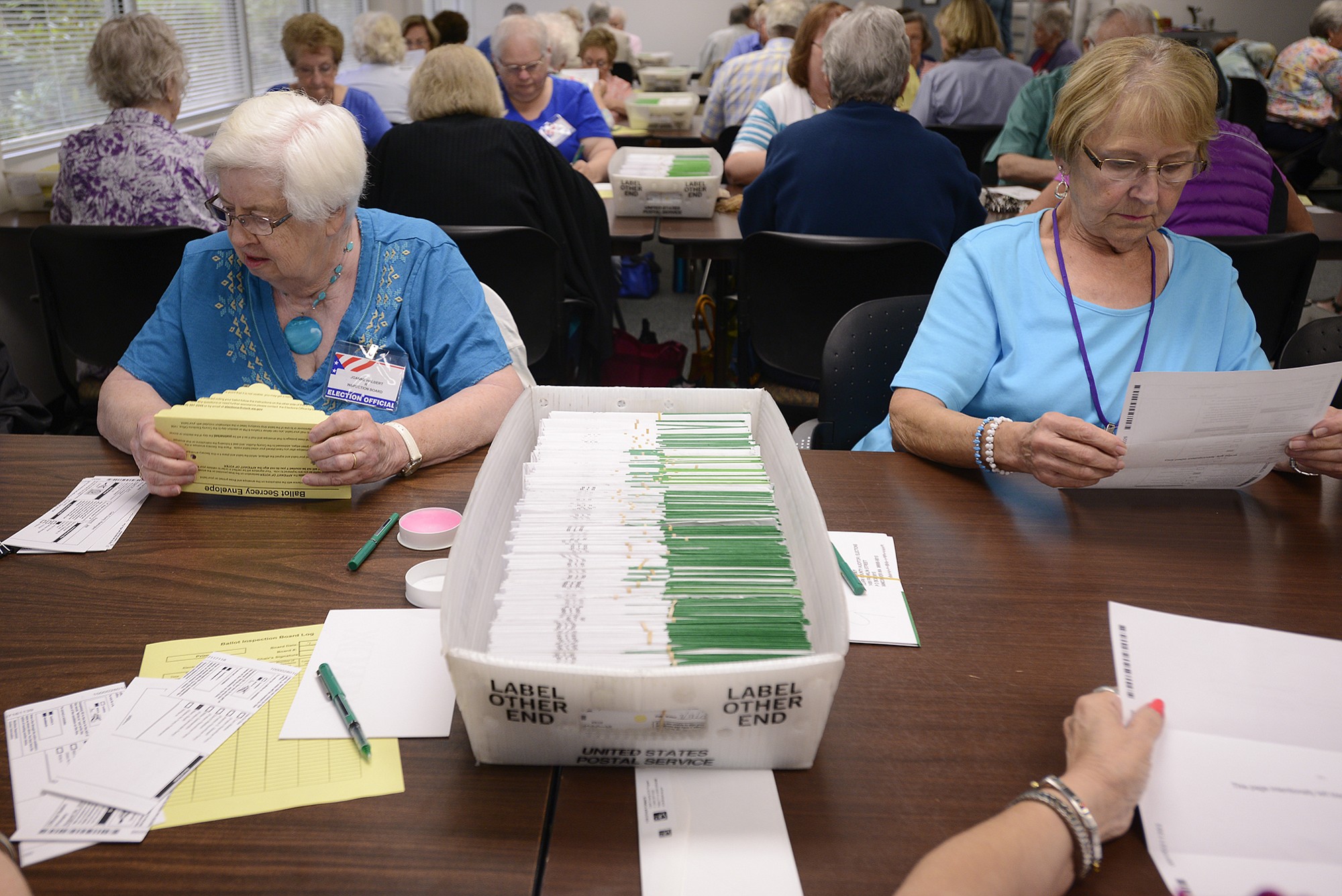 Joanne Halbert, left, and Margie Brown inspect and sort primary election ballots at the Clark County elections office on Wednesday.