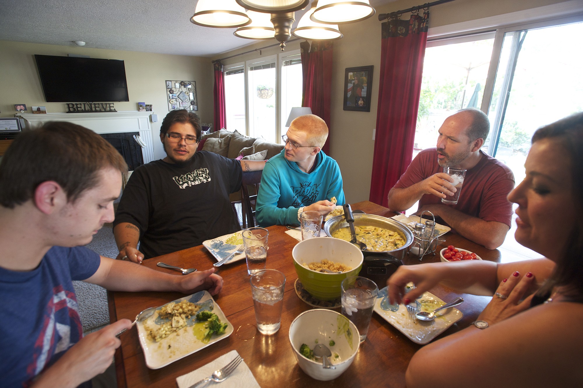 Jose Ramirez, 20, from second from left, and Tayler O'Bryant, 19, eat dinner with the Bilby family, David, Diana and Kent, on Tuesday.