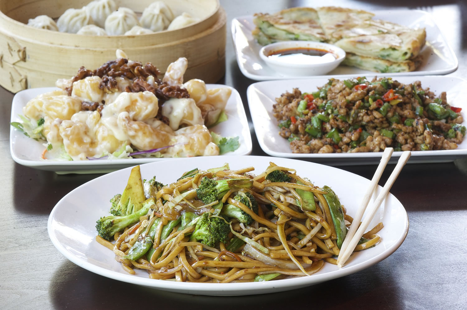 Chow mein with vegetables, crispy walnut prawns, chopped pepper hot chicken, green onion pancakes and steamed dumplings are served Oct.