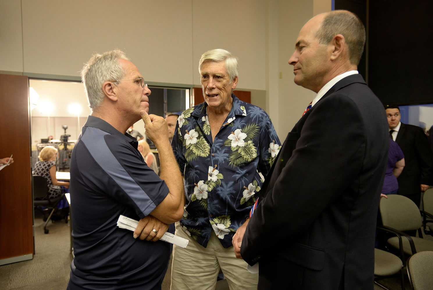 Marc Boldt, left, chats with Michael Langsdorf of Vancouver and Clark County Auditor Greg Kimsey, right, at the county Public Service Center Tuesday night.