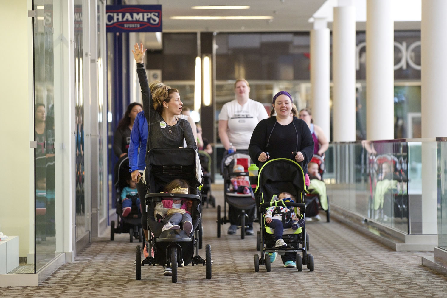 Vancouver moms Reagen Darling, left, and Shelly Stafford walk a lap around the Westfield Vancouver mall during a recent Barbells and Bottles class.