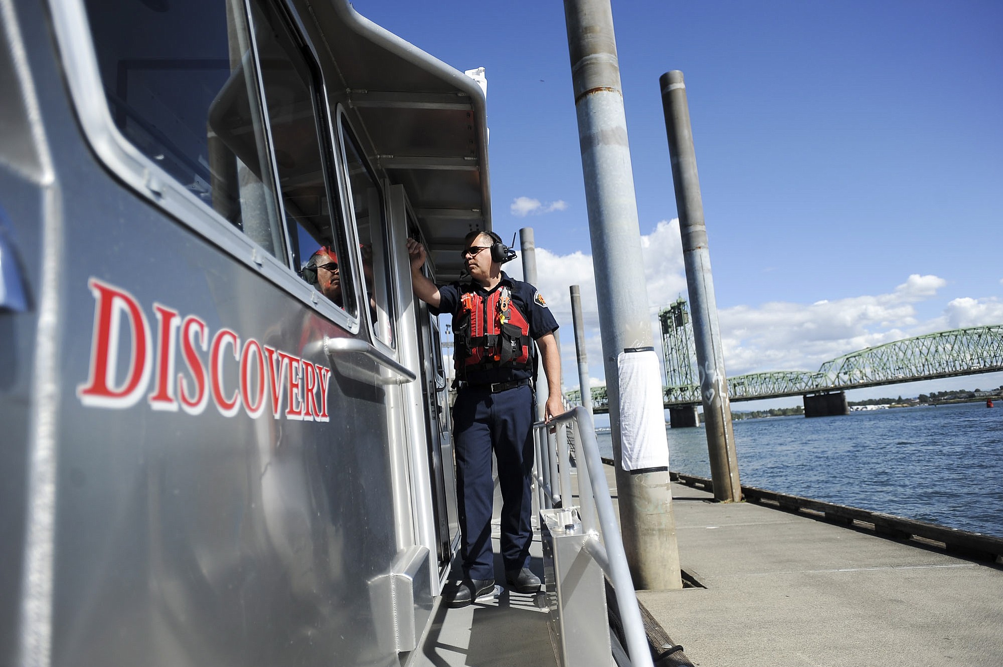 A Vancouver firefighter helps out on a tour Monday of the Columbia River along the Vancouver waterfront.