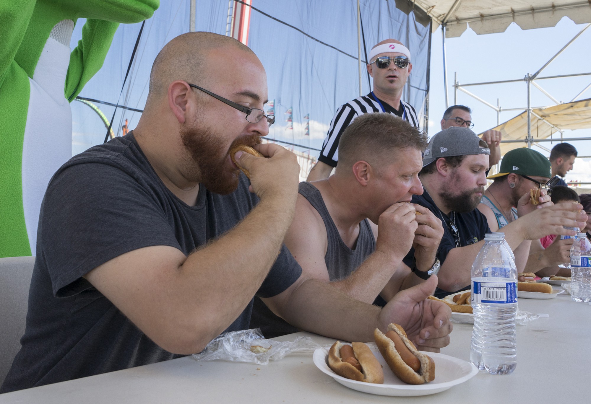Chris Munoz of Vancouver, left, finishes his eighth hot dog Sunday afternoon during a hot dog eating contest at the Clark County Fair. Munoz won the competition.
