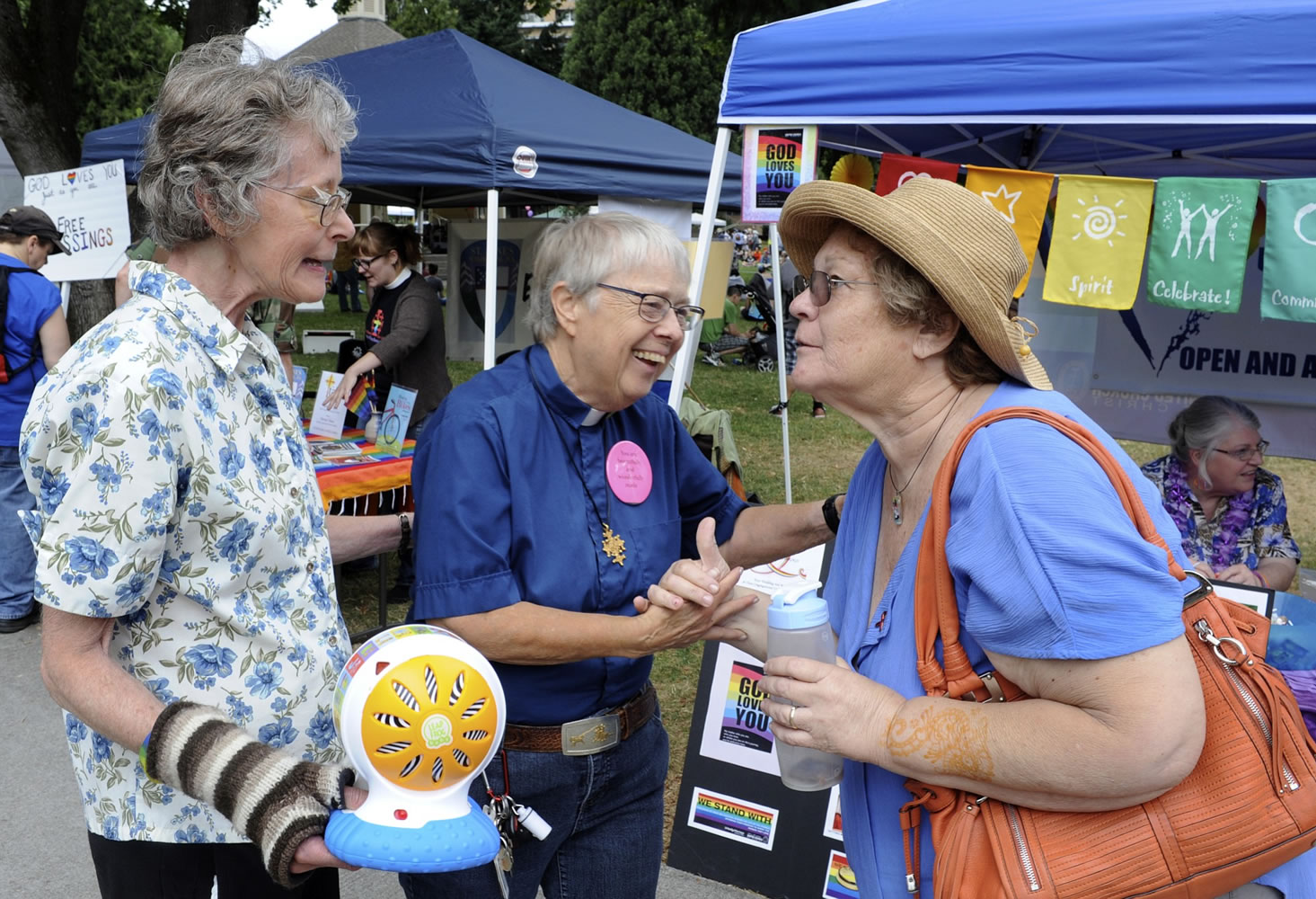 Adina Tarpley, left, and Carole Elizabeth, who have been together for 25 years, greet Lee Kendel, right, at this year's Saturday in the Park Pride event.