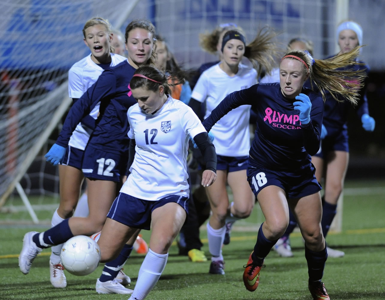 Olympia High School's Brooklyn Hooper (18) ) defends a clearance by Skyview's Sydnee Smith (12) in a girls' 4A state soccer playoff game at Kiggins Bowl on Wednesday Nov. 12, 2014. Olympia won on penalty kicks.